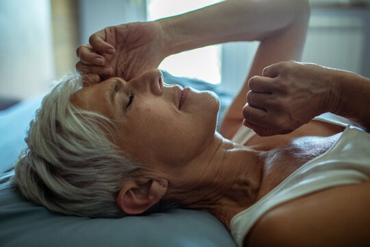 Senior woman waking up in the morning in bed