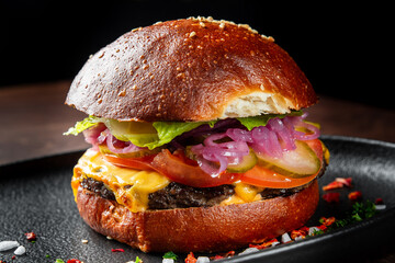 A close-up of a delicious gourmet burger featuring a juicy beef patty, melted cheese, fresh lettuce, tomato, pickles, and pickled onions, all nestled in a shiny brioche bun.
