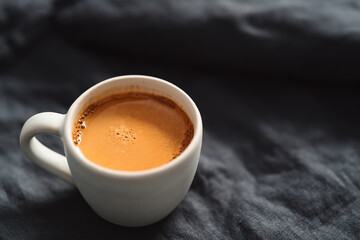 hot espresso in white cup on linen cloth with copy space