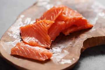 Smoked salted salmon slices on wood board