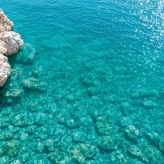 Obraz premium Bright Sunlight on Clear Turquoise Water with White Rocks