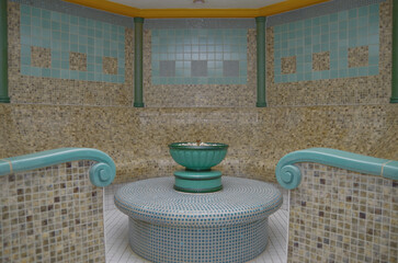Turkish bath or steam sauna with mosaic tiles inside male locker room of spa or wellness are...