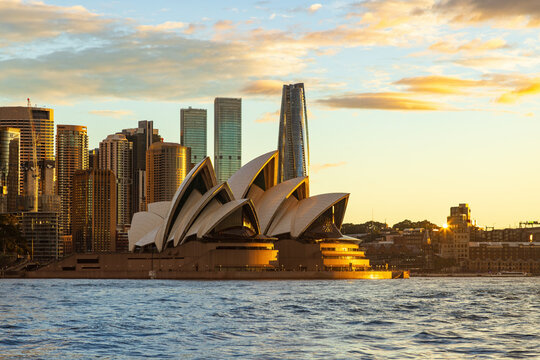 Sydney, Australia. The iconic Opera House and the city's skyscrapers at sunset, seen from Sydney Harbour