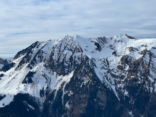 Obraz premium Beautiful sunlit and snow-capped alpine peaks above the Swiss tourist sports-recreational winter resort of Engelberg - Canton of Obwalden, Switzerland (Kanton Obwald, Schweiz)