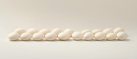 White eggs arranged on white background; minimalist food photography; studio shot