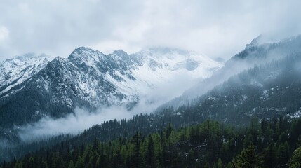 Obraz premium Majestic Mountain Range with Fresh Snow Under Cloudy Sky