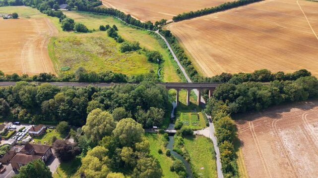 Aerial panning left, Darent river, rural valley, Eynsford Viaduct