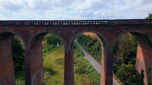 Aerial tilt down close-up, overpass rail structure, English countryside