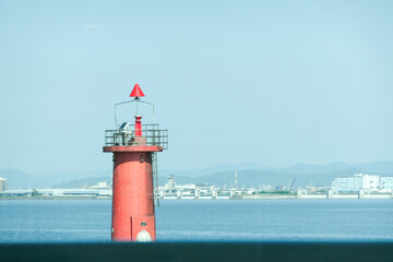 静かな海に立つ赤い灯台