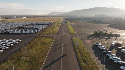 Flying over highway near mass storage parking lot in vast area