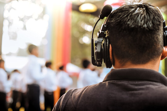Stage manager using wireless intercom headset while watching and directing stage live performance