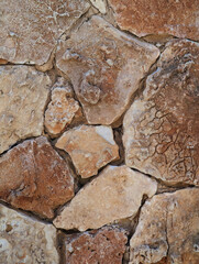 Beige and brown natural stone masonry wall texture, irregular friable stones with concrete for house walls, privacy dividing wall, facades. Stone and rock surface background in rustic style. 
