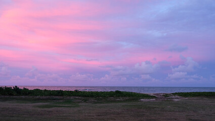 美しいピンクと紫のグラデーションの夕焼け空と海