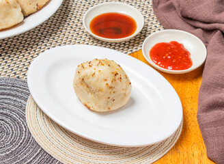 Shanghai Fried Buns or Momo with Dipping Sauce served in plate isolated napkin side view of chinese dim sum food