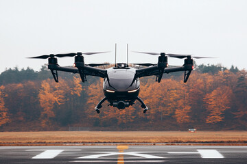 Taxi drone is landing near autumn foliage