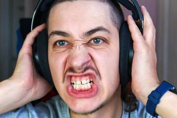 Expression of intense emotion during gaming in a cozy room filled with technology and excitement