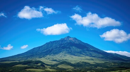 A serene mountain scene with a few clouds drifting lazily across the sky