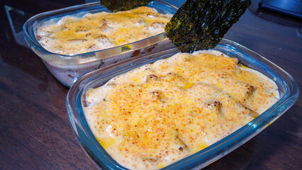 Chicken rice mentai served with seaweed on a transparent bowl 