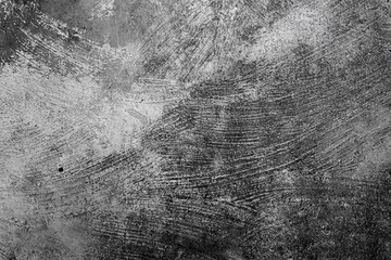 Grunge texture of a concrete surface with circular scratches and distressed details in black and white.