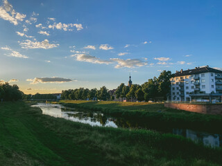 Fototapeta premium River runs through a town with a large building in the background
