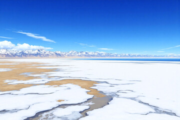 Fototapeta premium Snow covered land with mountains in background