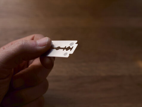 Hand holding a razor blade