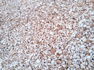 A pile of rough, white limestone fragments.
some are brown.