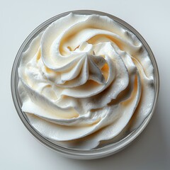 Close-up top view of swirled whipped cream in a bowl on white background