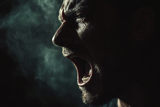 Close-up shot of a man shouting with intense emotion, capturing the raw expression of anger and frustration. The image symbolizes a strong emotional release or outburst.