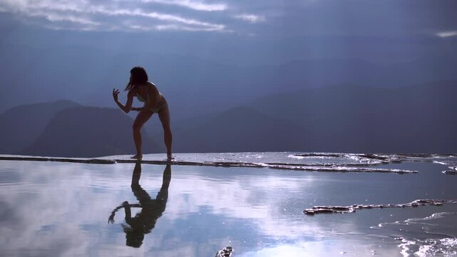 Asian Girl in Bikini is Dancing on the Edge of Natural Petrified Waterfall Hierve el Agua in Mexico, Oaxaca. 