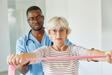 therapist senior man exercise exercising patient physical woman girl therapy care nurse recovery physiotherapy fitness stretching stretch band elderly support training