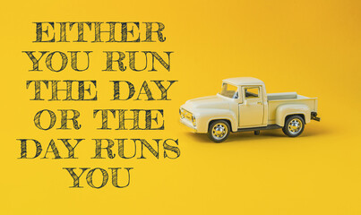 Yellow truck with the words either you run the day or the day runs you