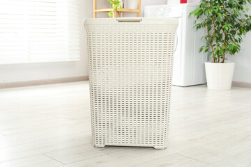 Wicker laundry basket on floor in bathroom