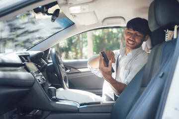 Smiling Man in Car:  A young man in a white shirt smiles cheerfully as he uses his smartphone in a car, showcasing the modern and connected lifestyle of urban commuting. 