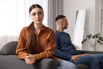 Offended couple ignoring each other at home, selective focus