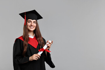 Happy student with diploma after graduation on grey background. Space for text