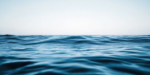 A serene view of calm ocean waves under a clear blue sky.