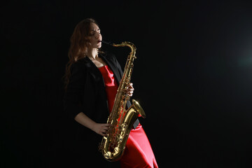 Professional musician playing saxophone on black background. Space for text