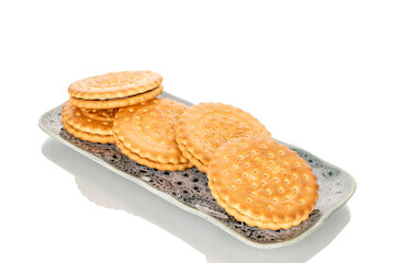 Several cookies on a ceramic saucer, macro, isolated on a white background.