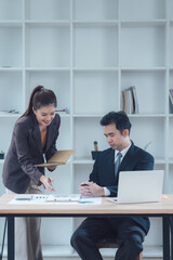 Strategic Collaboration: A focused business meeting in a modern office setting. A confident businesswoman presents key data points while a focused businessman analyzes the information.