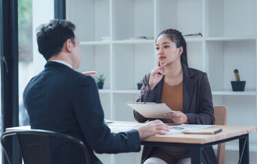 Job Interview Discussion: A serious yet attentive job candidate engages in a focused discussion with a recruiter, showcasing professionalism and active listening during a critical interview moment.