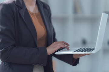 Businesswoman Working on Laptop: A close-up image of a businesswoman's hands typing on a laptop, capturing a moment of focus and dedication in a modern office setting.