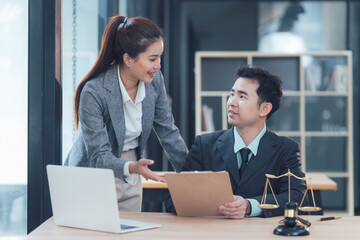 Legal Consultation: Two Asian lawyers, a man and a woman, are engaged in a professional discussion...