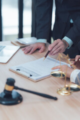 Legal Counsel: A close-up view of an attorney's hand pointing to a document during a client...