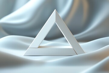 Elegant triangular sculpture on silky blue fabric.