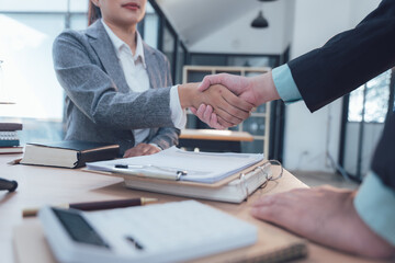 Business Deal Handshake:  A close-up shot of a business handshake between a man and a woman in a modern office setting,  symbolizing a successful agreement, collaboration.