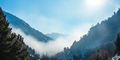 Misty mountain valley bathed in sunlight serene winter landscape with snow dusted peaks and evergreen trees