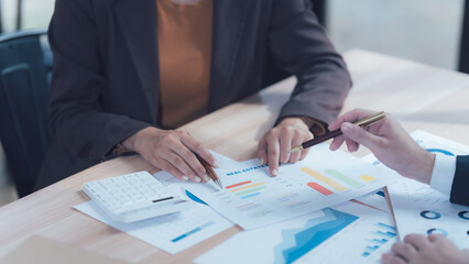 Business Discussion: A close-up shot of two professionals reviewing data, charts, and financial reports during a business meeting, showcasing collaboration and strategic planning.  