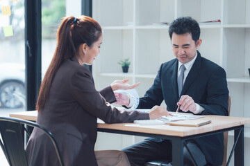 Business Discussion:  A serious yet engaging conversation unfolds as two business professionals meticulously analyze documents,  their focused expressions conveying a sense of intent and deliberation.