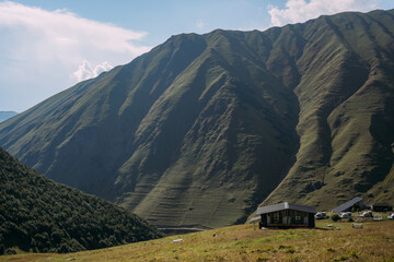The green mountains of the North Caucasus in Georgia near the village of Juta. A house in the mountains